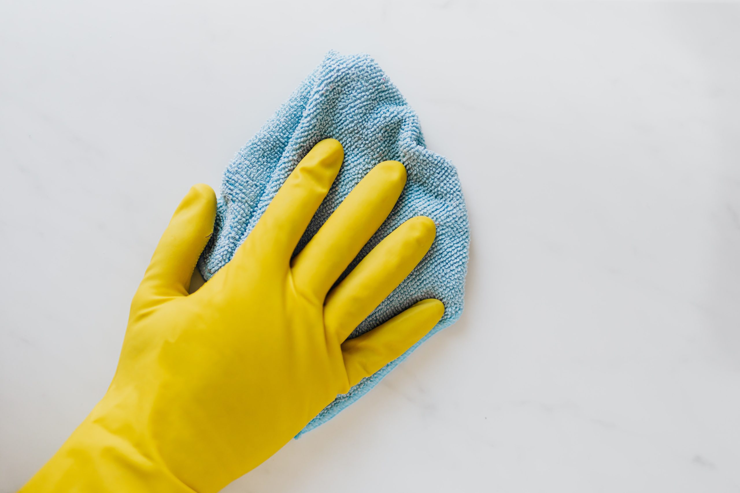 A yellow glove wiping with a blue rag.