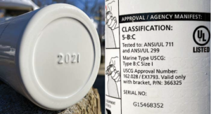 Close-up of a boat fire extinguisher with Coast Guard approval number on it.